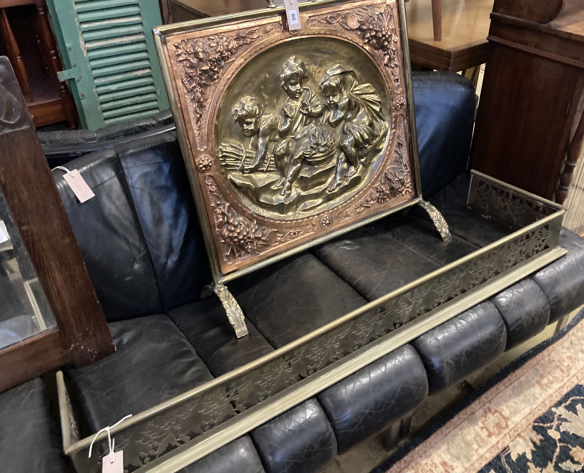 A embossed brass and copper fire screen, 70 x 70cm, together with a pierced brass fender